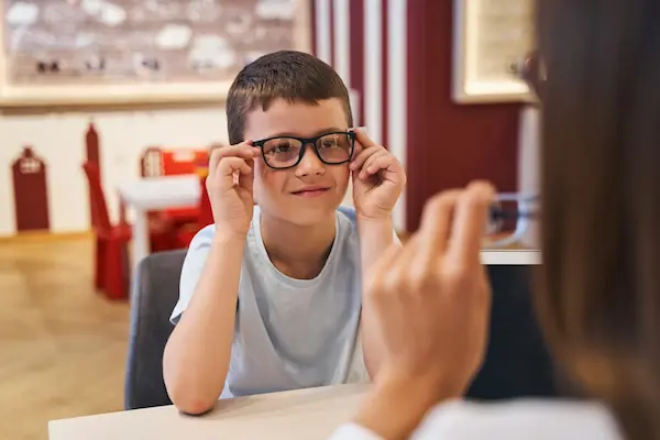 niño con lentes aplicando los tips útiles para la salud visual infantil